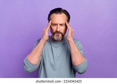 Portrait of unsatisfied sick ill person closed eyes arms on temples isolated on violet color background