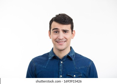 Portrait Of Unsure, Perplexed Man With Sarcastic Smile. Thoughtful Expression Of A Young Man Over White Background.