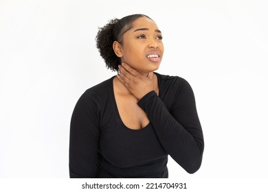 Portrait Of Unwell Young Woman Touching Sore Throat Against White Background. African American Lady Wearing Black Longsleeve Suffering From Cold Or Pneumonia. Illness Concept