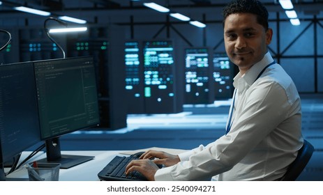 Portrait of upbeat admin in data center managing servers, operating systems and software programs. Joyous specialist in server hub ensuring networks are secure and functioning properly, camera A