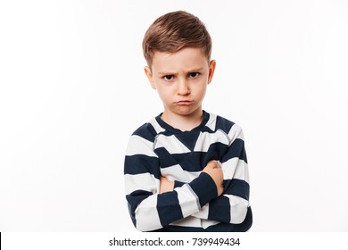 Portrait of an upset cute little kid standing with arms folded and looking at camera isolated over white background - Powered by Shutterstock