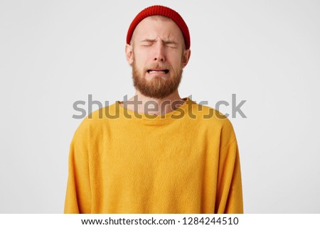 Portrait of upset distressed sobbing crying guy. Bearded man crying a river because of love, isolated over whire background