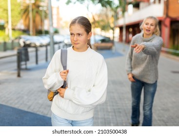 Portrait Of Upset Teen Girl Walking On City Street On Warm Autumn Day With Worried Mother Reproaching Her..