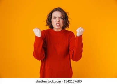 Portrait Of Uptight Woman 20s Wearing Sweater Gesturing And Yelling While Standing Isolated Over Yellow Background