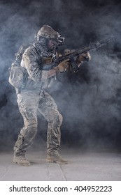Portrait of US Army Soldier in Action with Four-eyed night vision goggles in the Smoke; Dark and Foggy Background