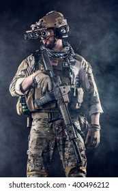 Portrait of US Army Soldier with Foue-eyed night vision goggles in the Smoke; Dark Background