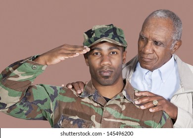 Portrait Of US Marine Corps Soldier With Father Saluting Over Brown Background