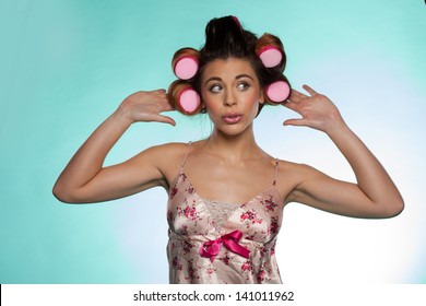 Portrait Of A Vain Pretty Young Woman Wearing A Flowery Satin Summer Pajama Showing Her Hair Rollers