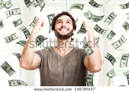 Portrait of a very happy young man in a rain of money