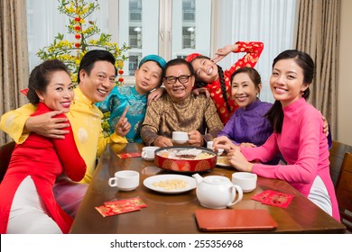 Portrait Of Vietnamese Family In National Costumes Gathered At The Tet Table