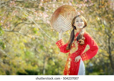 Portrait of Vietnamese girl traditional dress, red Ao dai is famous traditional costume for woman in Vietnam.