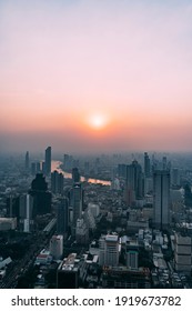 Portrait View Of Bangkok At Sunset From Skyscraper, Looking Down On Chao Praya River And Cityscape.