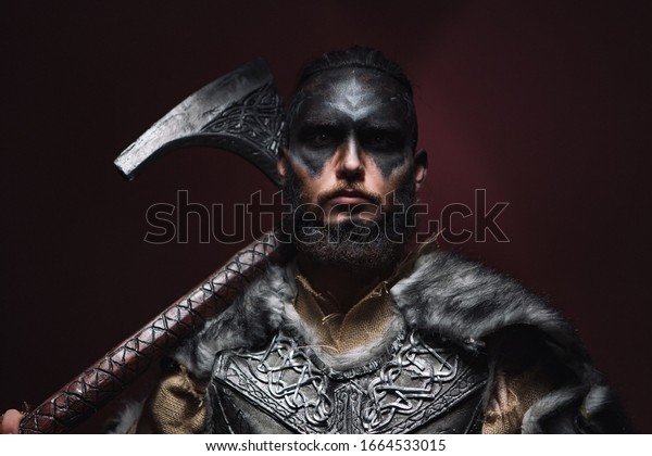 portrait of a Viking man with an axe. A man of 30\
years holds a large battle axe on his shoulder. Warrior dressed in\
an authentic suit