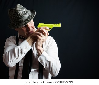 Portrait Of Vintage Private Eye Detective Holding Toy Gun. Comedic Action Hero Concept.