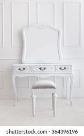 Portrait Of Vintage Vanity Table Set With Stool And Mirror On White Patterned Wall