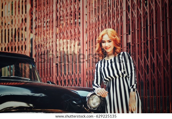 Portrait of\
Vintage woman fashion with vintage\
car.