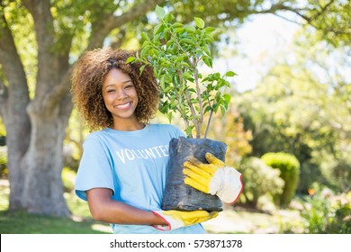 Portrait Of Volunteer Woman Holding Plant In Park