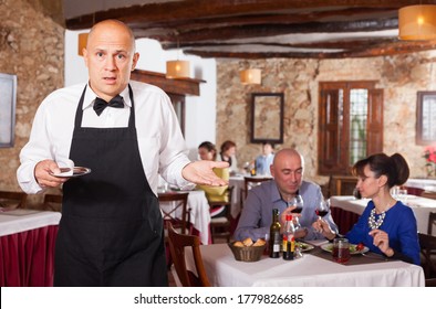 Portrait Of Waiter In Black Apron Upset With Little Tips At Restaurant