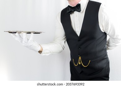 Portrait of Waiter or Butler in White Gloves Holding Silver Tray on White Background. Concept of Service Industry and Professional Hospitality.