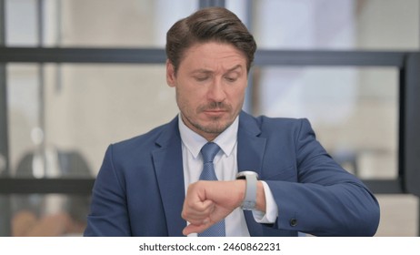 Portrait of Waiting Middle Aged Businessman Checking Time on Wrist Watch - Powered by Shutterstock