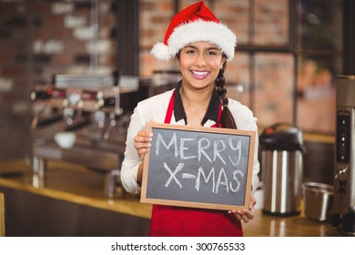 Portrait of a waitress with a chalkboard merry x-mas at the coffee shop - Powered by Shutterstock