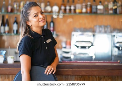Portrait of waitress standing near the restaurant bar of the hotel. A waitress with a tray is waiting for the order