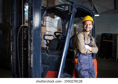 Portrait Of Warehouse Forklift Driver Standing In Storehouse By The Machine.