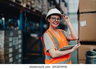 Portrait Of A Warehouse Worker Standing In A Distribution Center. Caucasian Female Looking At Camera. Concept Of Occupation And Career.