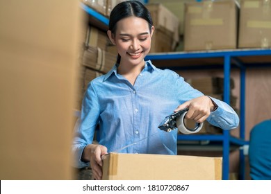 Portrait of Warehouse worker woman packing cardboard box with sticky tape with Indian worker man in local warehouse or factory,industry and export business concept, partner and colleague work together