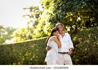 Portrait Of Wealthy Couple In Their Backyard.