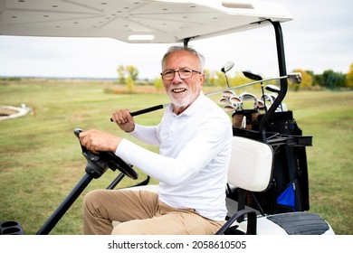 Portrait Of Wealthy Senior Man Driving Golf Car To The Green Zone To Continue Playing.