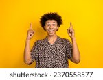 Portrait of wearing leopard stylish guy youngster pointing fingers up empty space crazy hot cheap offer isolated on yellow color background