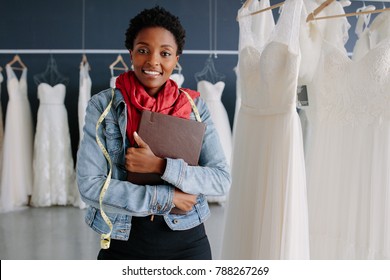 Portrait Of Wedding Dress Store Owner With A Diary. Woman Dressmaker In Her Bridal Boutique.