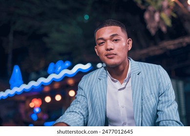 Portrait of a well dressed young man wearing a stylish blue suit and white shirt at a bar. He exudes confidence and charisma. - Powered by Shutterstock