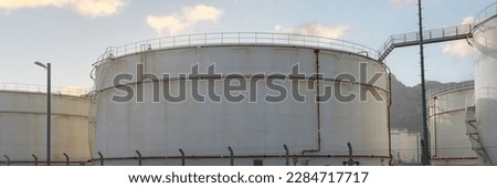 Portrait of white petrochemical storage tanks or tank farm. Crude oil export factory industry or fuel storage