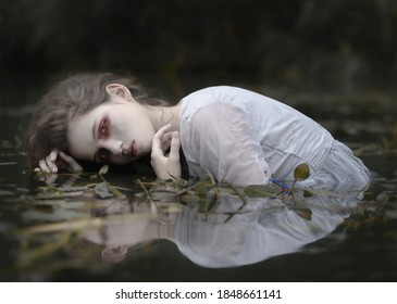 Portrait of a white-skinned woman in the water among the algae