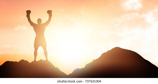 Portrait of winning boxer with arms raised against sunset with clouds