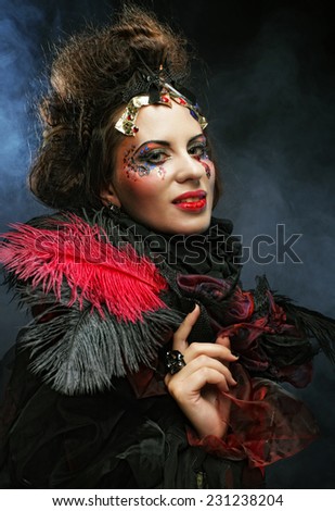 portrait of woman with artistic make-up in blue smoke, party theme