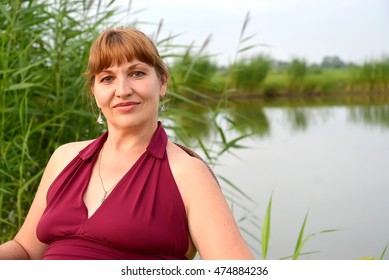Portrait Of The Woman Of Average Years Against The Background Of The Lake