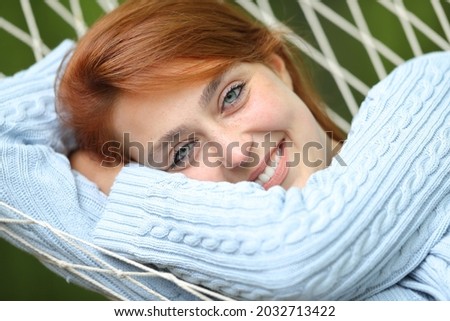 Portrait of a woman with beautiful blue eyes resting on hammock 