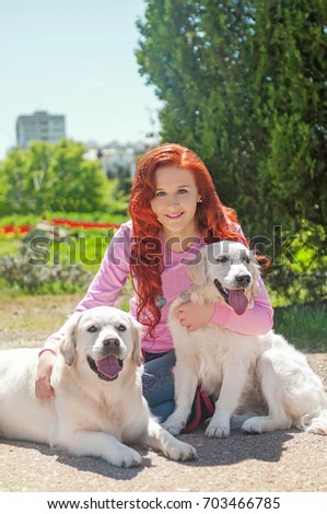 Portrait of woman with beautiful dog playing outdoors. Beautiful woman playing with golden retriever. Outdoor portrait. series. Red haired girl with retriever dog outdoors