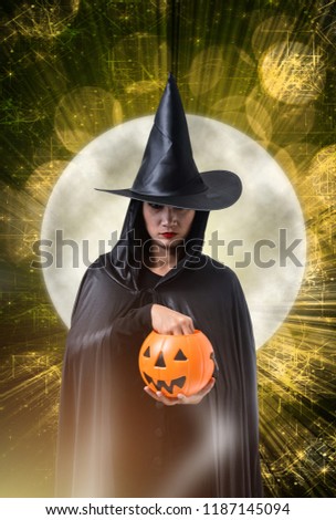 Portrait of woman in black Scary witch halloween costume Holding halloween pumpkin, magic lights and big moon with Halloween art design background