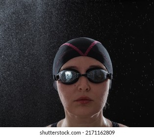 Portrait Of A Woman In A Black Swimming Cap. On His Head Are Swimming Goggles. Small Drops Of Water Are Visible On The Glasses

