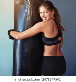 Portrait, woman and boxer with punching bag, wellness or exercise for health, challenge and sports on grey background. Club, athlete and healthy girl in gym, workout and fighter with energy and smile - Powered by Shutterstock