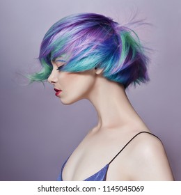 Portrait of a woman with bright colored flying hair, all shades of purple. Hair coloring, beautiful lips and makeup. Hair fluttering in the wind. Sexy girl with short hair