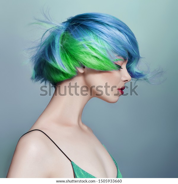 Portrait of a woman with bright colored flying\
hair, all shades of blue purple. Hair coloring, beautiful lips and\
makeup. Hair fluttering in the wind. Sexy girl with short  hair.\
Professional coloring