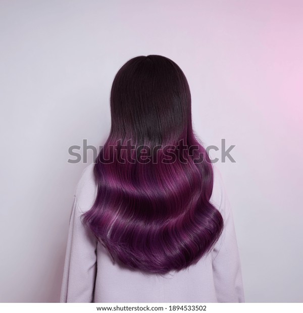 Portrait of a woman with\
bright colored flying hair, all shades of purple. Shiny Healthy\
colored Hair coloring, beautiful lips and makeup. Sexy girl with\
long hair styling