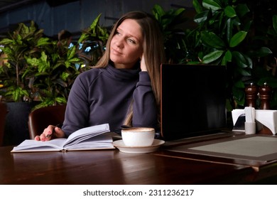 Portrait of a woman in a cafe. The woman thinks. Mental health.
 - Shutterstock ID 2311236217