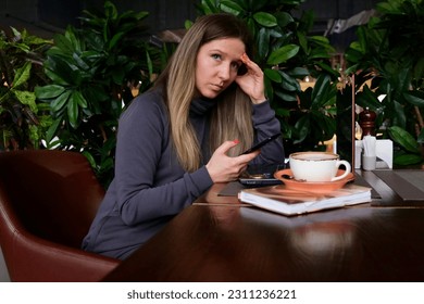Portrait of a woman in a cafe. The woman thinks. Mental health.
 - Shutterstock ID 2311236221