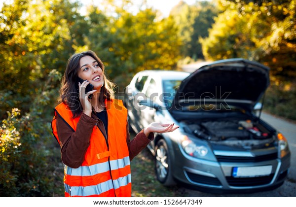 Portrait of woman calling\
car assistance